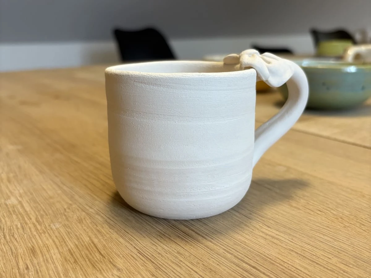 Kop med sløjfe-hank – hånddrejet keramikkop du selv maler i værkstedet